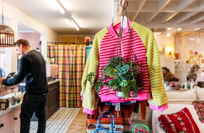 A yellow and pink jacket on display on a clothing rack.