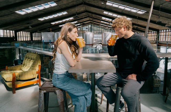 Two people drinking at table on mezzanine area of Three Boys Brewery in Christchurch.