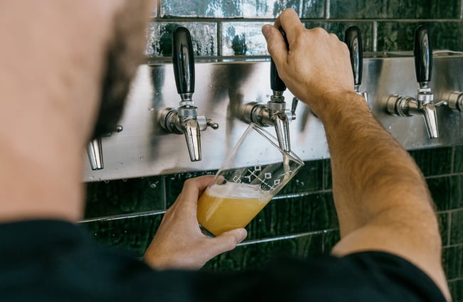 Worker pulling a pint using large wooden handles.