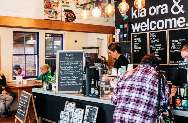 A woman making coffee behind the counter at Three High Street cafe in Rangitikei.