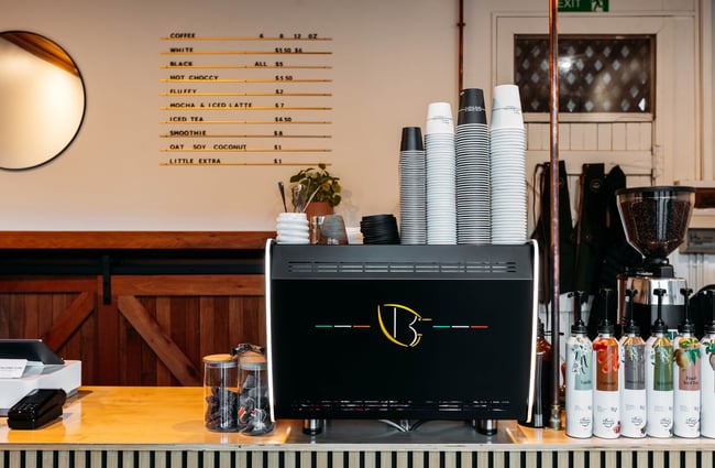 A black espresso machine on a cafe counter.