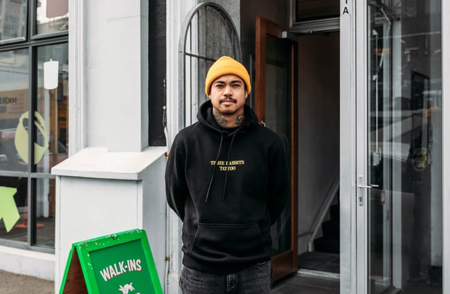 Tattoo artist standing outside Three Rabbits Tattoo.
