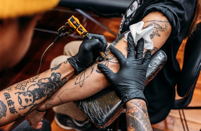 Tattoo artist tattooing at Three Rabbits Tattoo.