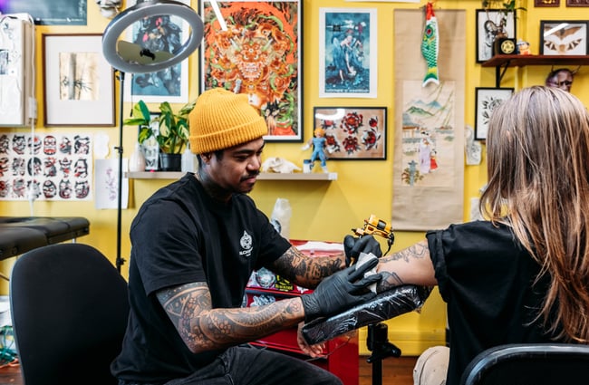 Tattoo artist at work in Three Rabbits Tattoo.