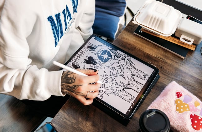 Tattoo artist drawing a design at Three Rabbits Tattoo.