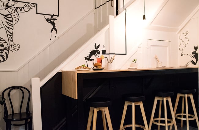 Black bar stools by a high table.