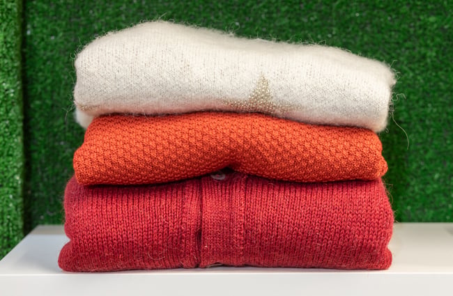 Close up of jumpers folded on a shelf at To Be Continued.