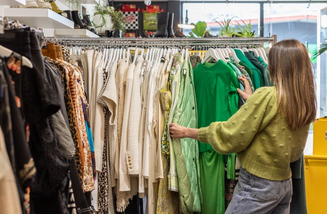 Customer browsing the clothing racks at To Be Continued.