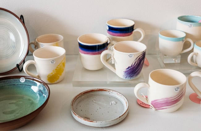 A close up of painted mugs on display.
