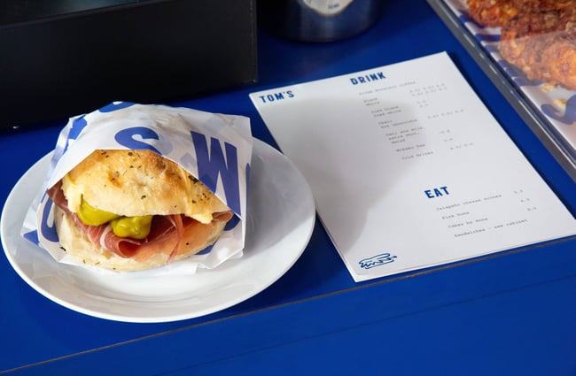 A sandwich and menu sitting on a blue table.