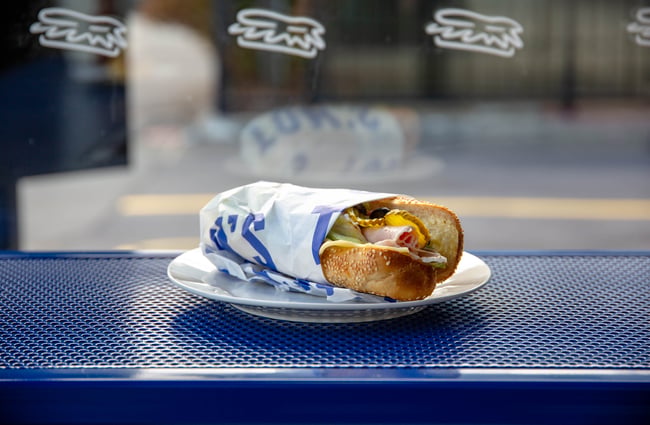 Close up of a sandwich on a blue bench.