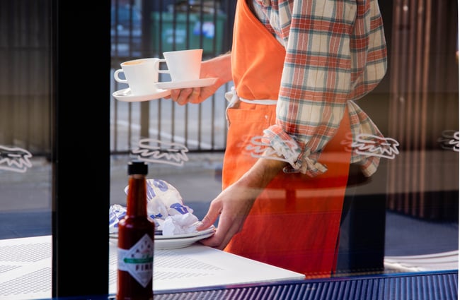 A staff member clearing plates.