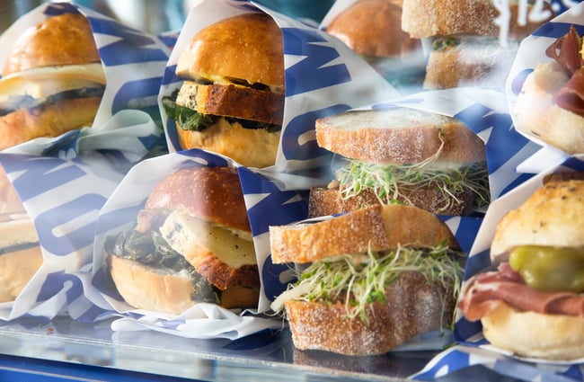 An extreme close up of sandwiches behind a glass counter.