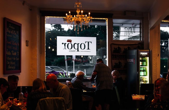 Customers being served at their table by waiter at Topor.