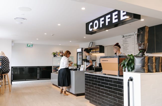 A large 'coffee' sign above the counter inside a cafe.