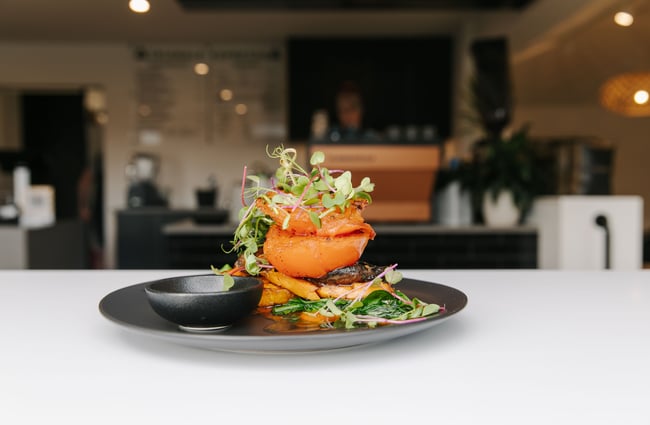 A close up of a vegetable stack on a plate.