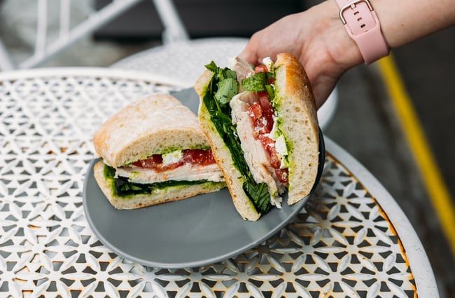 Chicken sandwich being placed on the table at Tricky's Sandwich Co