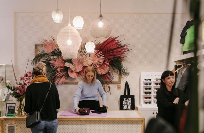 Woman serving a customer at the counter at Trouble and Fox.