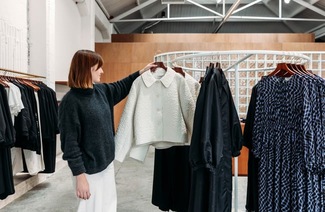 Shop assistant holding an item of clothing at twenty-seven names.