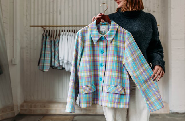 Shop assistant holding an item of clothing at twenty-seven names