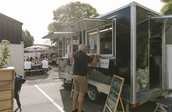 A man ordering at a food caravan.