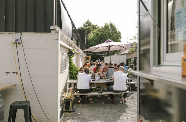 People dining on picnic tables on a sunny day.