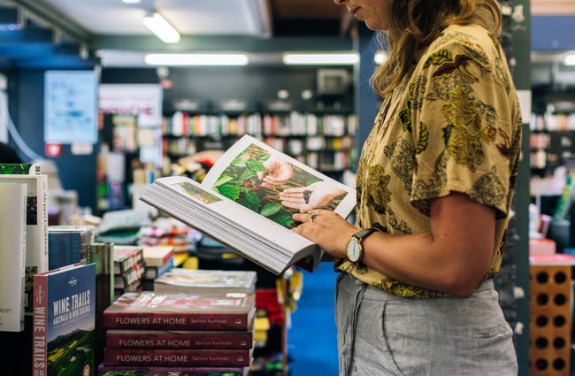 A woman looking at a book at the University of Canterbury Bookshop.