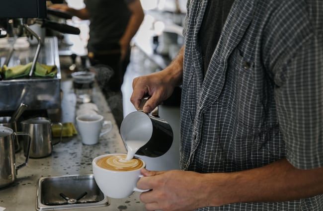Pouring steamed milk into a cup.