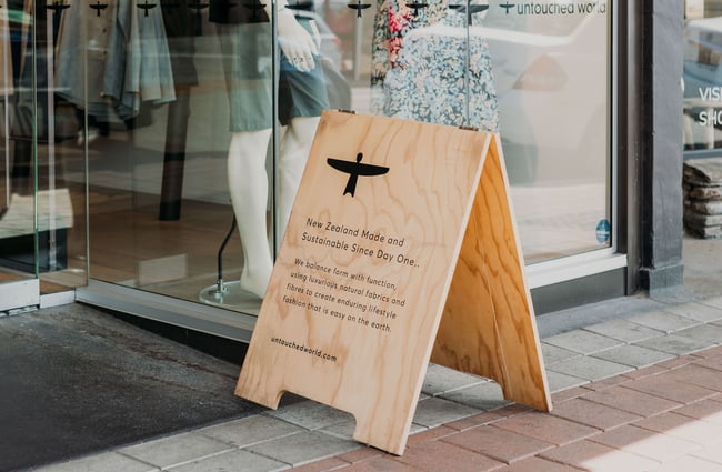 The wooden footpath sign outside Untouched World, Wānaka.