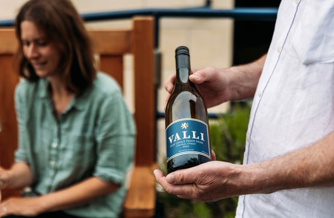 Waiter holding bottle of VALLI Post Office Pinot Noir wine