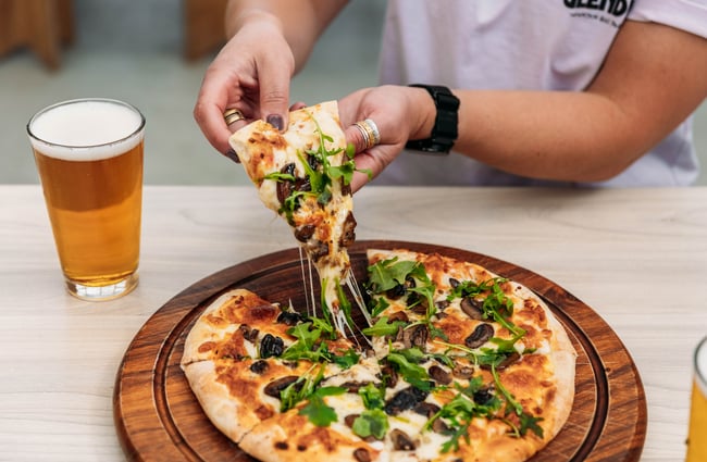 Slice of pizza and a pint of beer at Velo Café & Beer Garden.