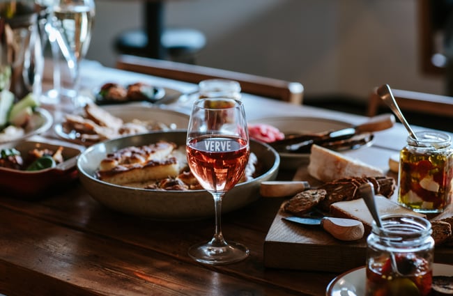 Glass of wine and spread of food at Verve.