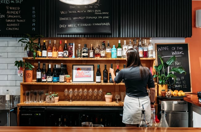 Bartender selecting a bottle of alcohol behind the bar at Verve.