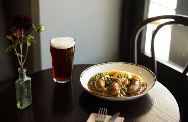 A beer and bangers and mash on a table at Victoria Free House Christchurch.