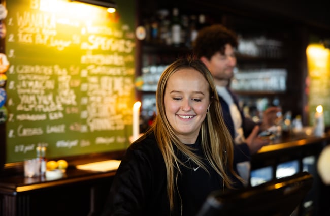 A woman smiling whilst looking down.