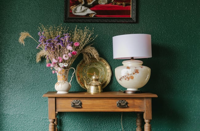 Vintage homewares and dried flowers on a small table.