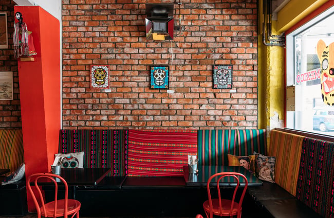 Interior of Mexican restaurant with exposed brick walls, Mexican skull mosaics and Day of the Dead decor