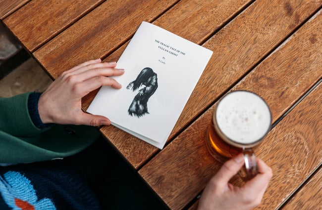 Hands on a menu and a beer.