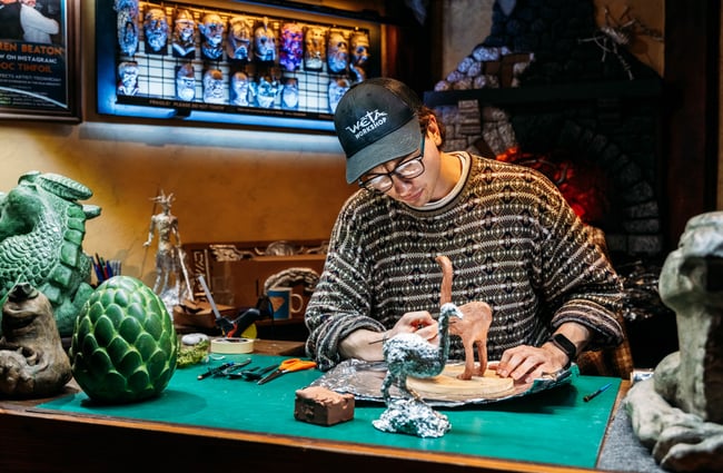 A man painting a figurine.