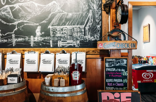 Menus and bottles of sauces on display on old wine barrels.