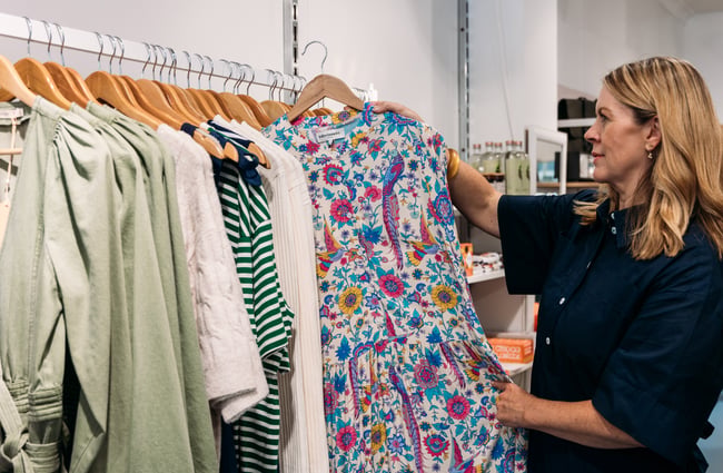 A woman holding a floral dress.