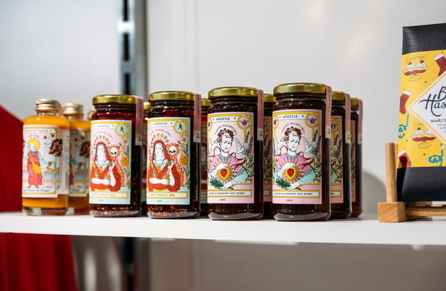 A close up of jars of chilli sauce on a shelf.
