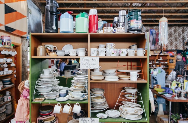 Close up of ceramic cups and plates on a shelf.