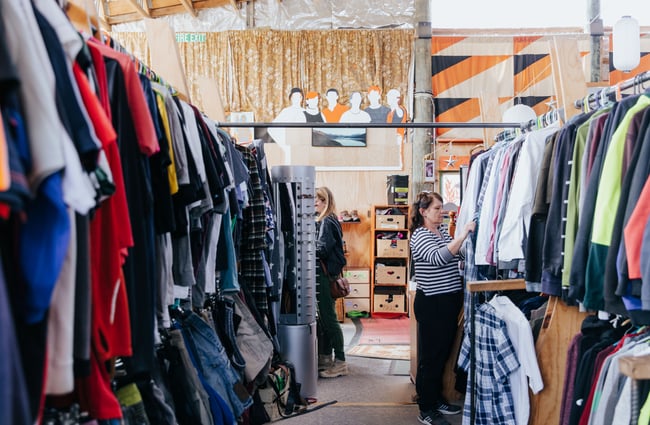 A woman browsing through secondhand clothing.