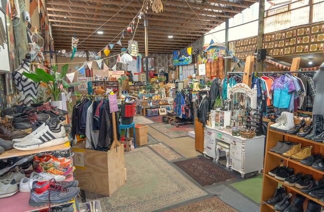 Main shop floor displaying second hand goods on racks and shelves at Wastebuster.