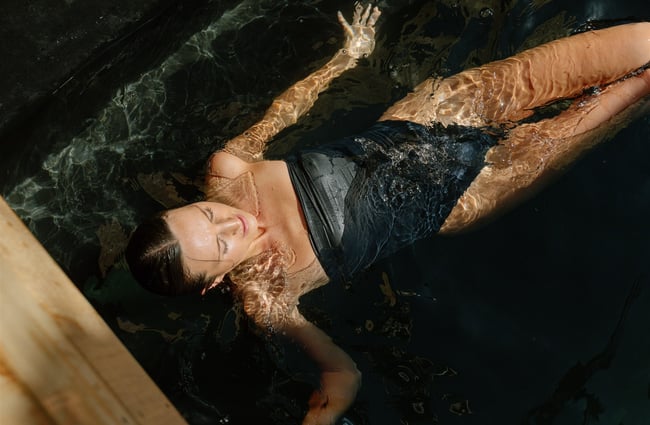 Woman floating in plunge pool at Watershed Saunas in Queenstown