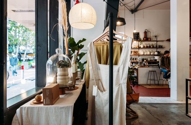 Close up of linen dressing gowns on rack by the window at Wellington Apothecary