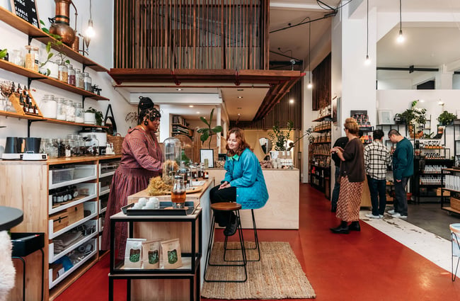 Woman helping customer at counter at Wellington Apothecary