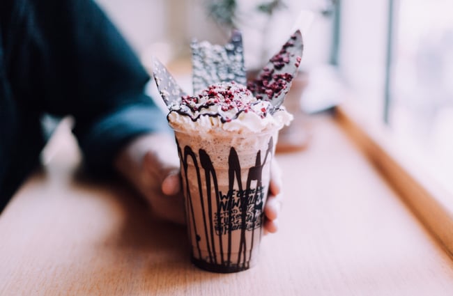 A hand holding an iced chocolate.