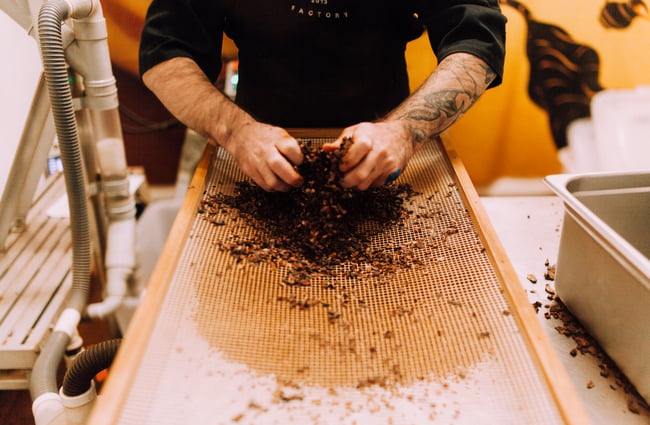 A man making chocolate with his hands.